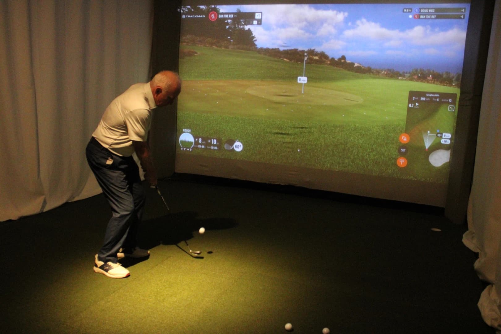 Steve Gonsalves mid-swing in a TrackMan golf simulator